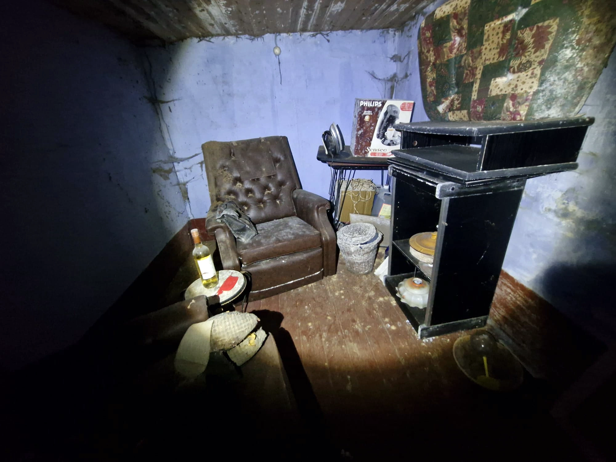 Volgepakte woonkamer van de verlaten boerderij waar de tijd is blijven stilstaan