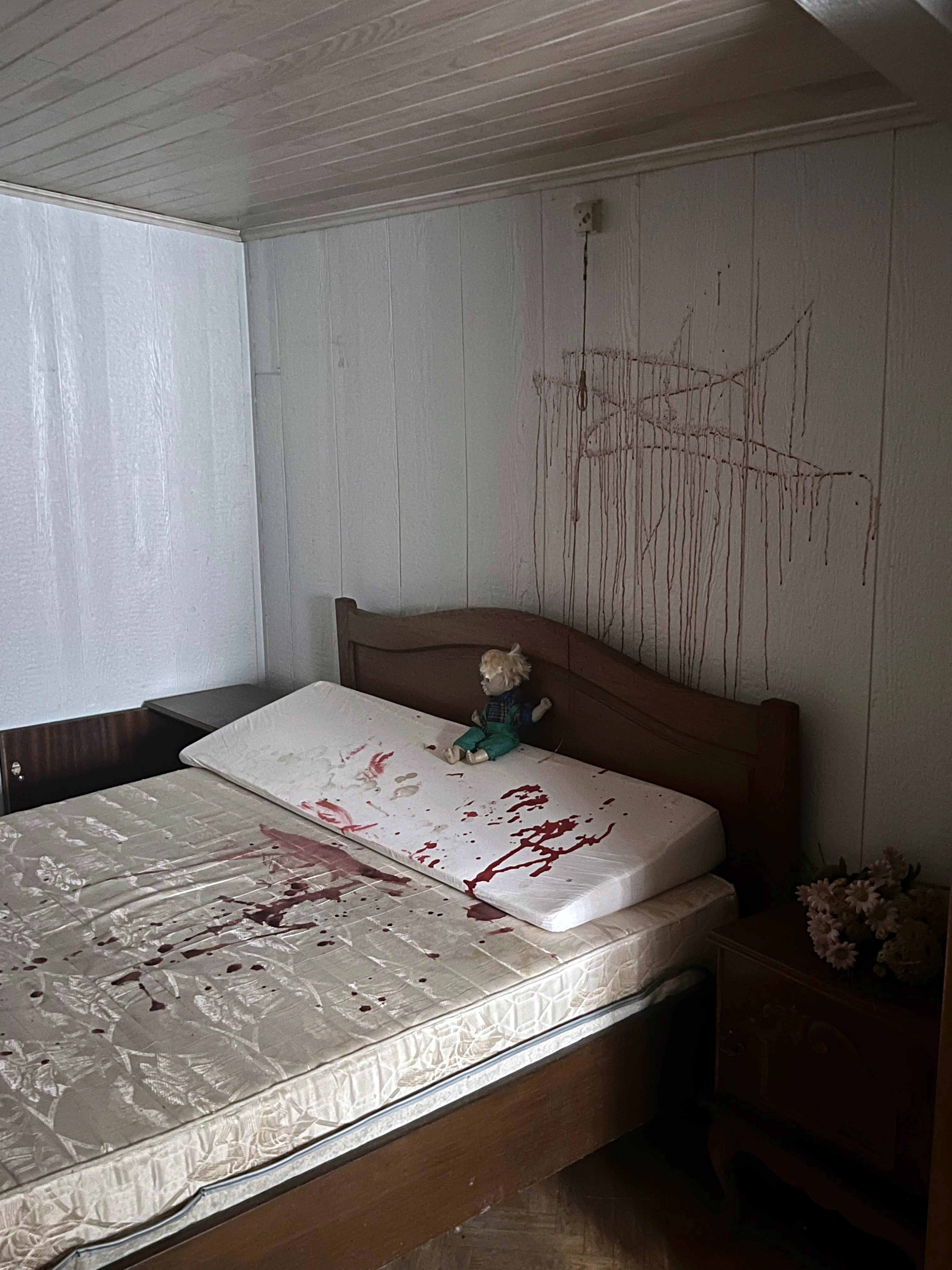 Slaapkamer in De Zwarte Hoeve met een bed besmeurd met nepbloed door hangjongeren