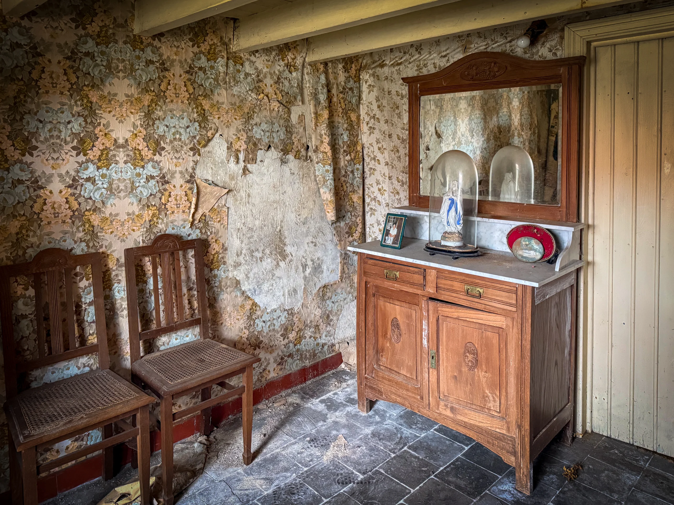 Overwoekerde binnenplaats van de boerderij waar de natuur de gebouwen herovert