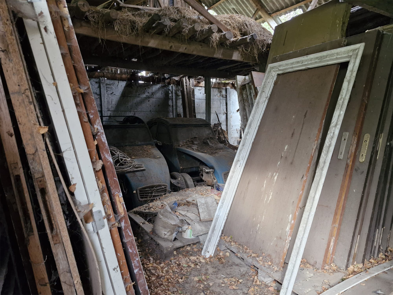 Verlaten schuur vol stof en oude auto onderdelen in België