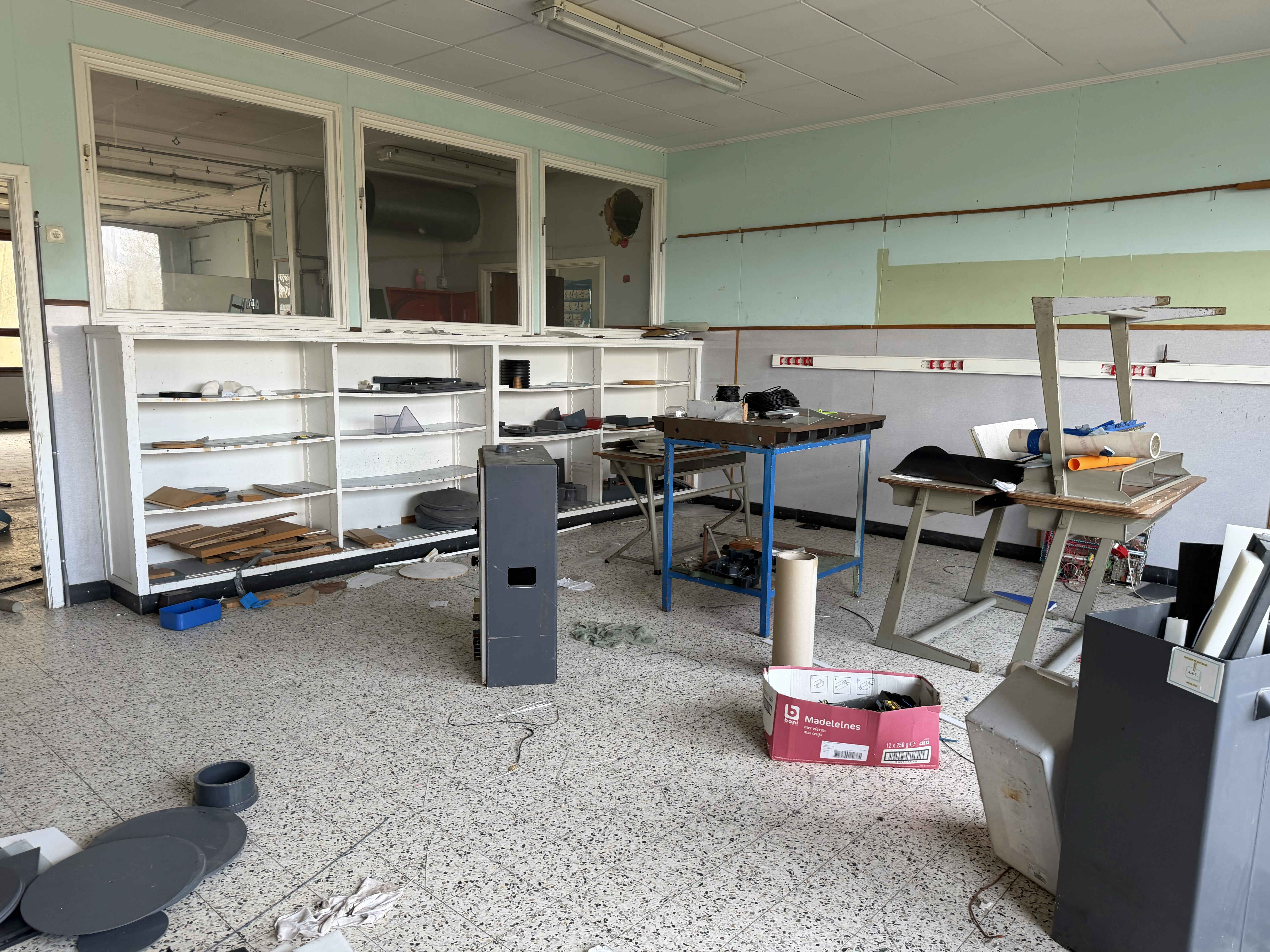 Detail van een roestige draaibank in het mechanica-lokaal van de verlaten school